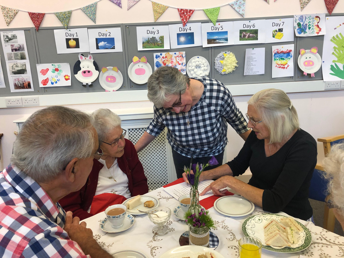 Superintendent Irena helping Ken, Ruby, and Anita with the quiz